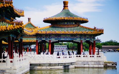 white and brown concrete building near body of water during daytime